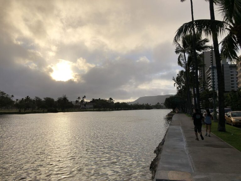 Joggers on the Ala Wai Canal path in Waikiki at sunrise