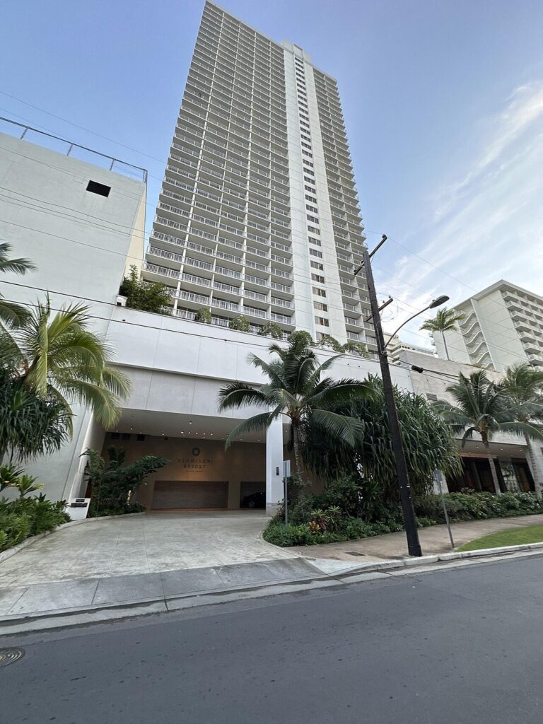 The Alohilani Resort tower and porte-cochere with the resort sign