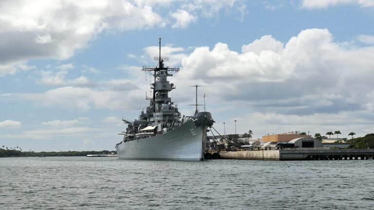 The gray Battleship Missouri moored at Ford Island under a blue sky