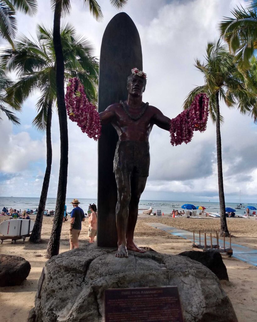 The bronze Duke Kahanamoku statue on Kuhio Beach in Waikiki, arms open