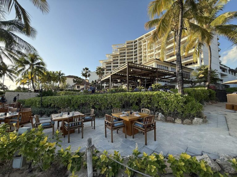 An oceanside dining terrace at the Four Seasons Oahu with the tower behind