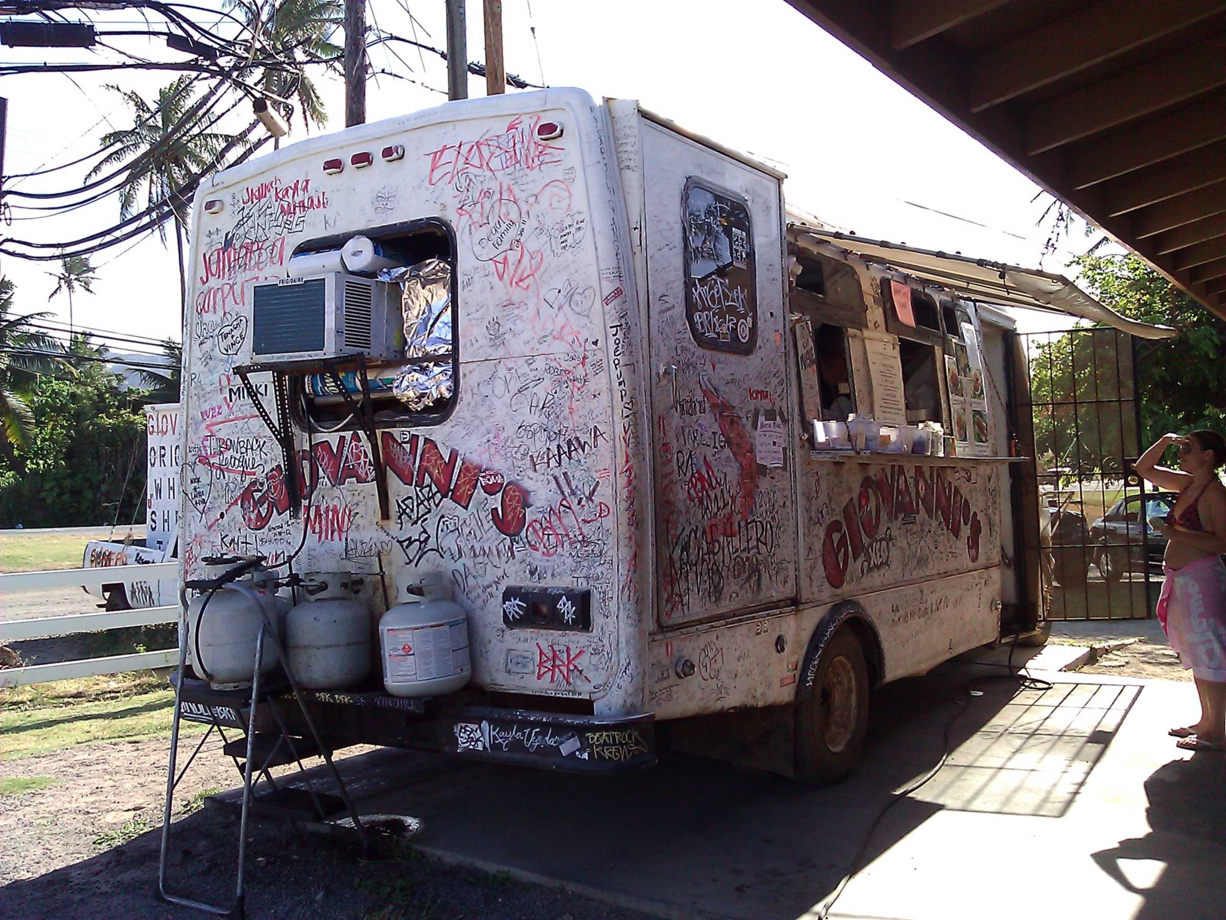 Giovanni's signature-covered shrimp truck under its pavilion in Kahuku