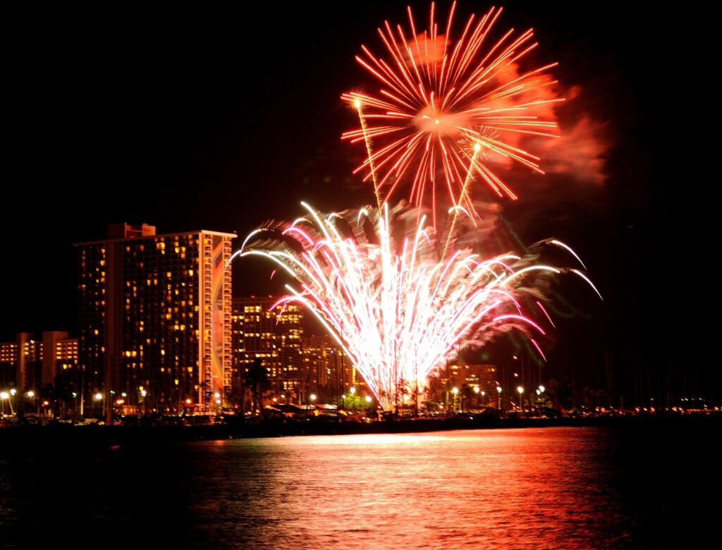 Fireworks over the water beside the Hilton Hawaiian Village towers in Waikiki
