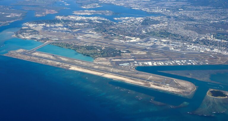 Aerial view of Honolulu airport with the Reef Runway built out over turquoise water