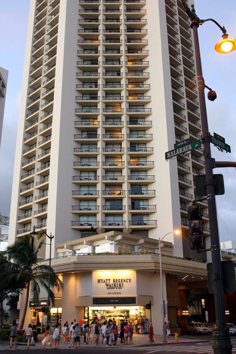 The Hyatt Regency Waikiki tower at a Kalakaua Avenue corner at dusk
