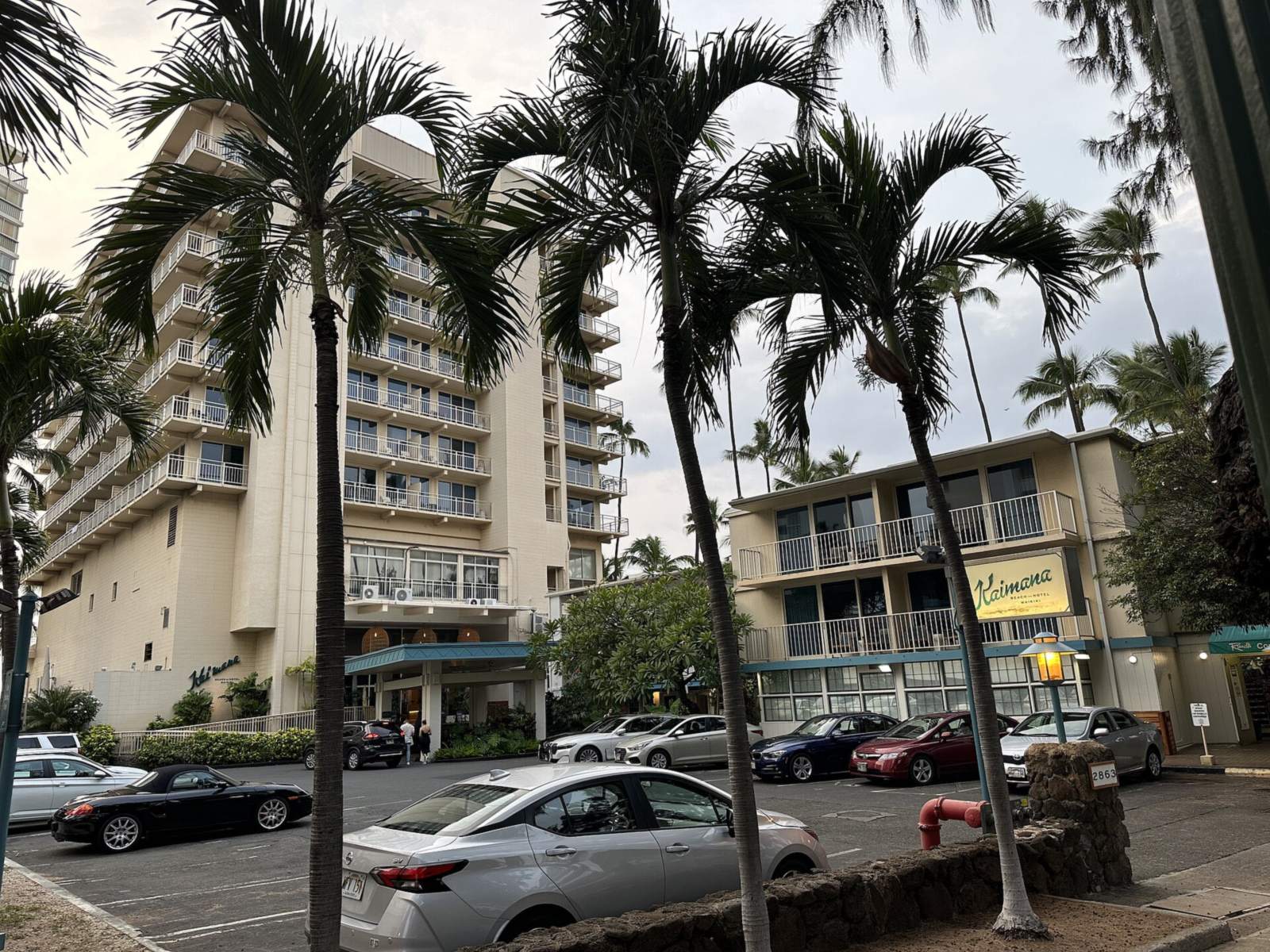 The Kaimana Beach Hotel building behind palm trees