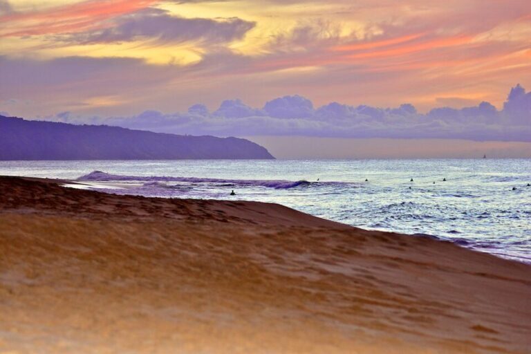 Sunset over Ke Iki Beach on the North Shore with surfers in the water