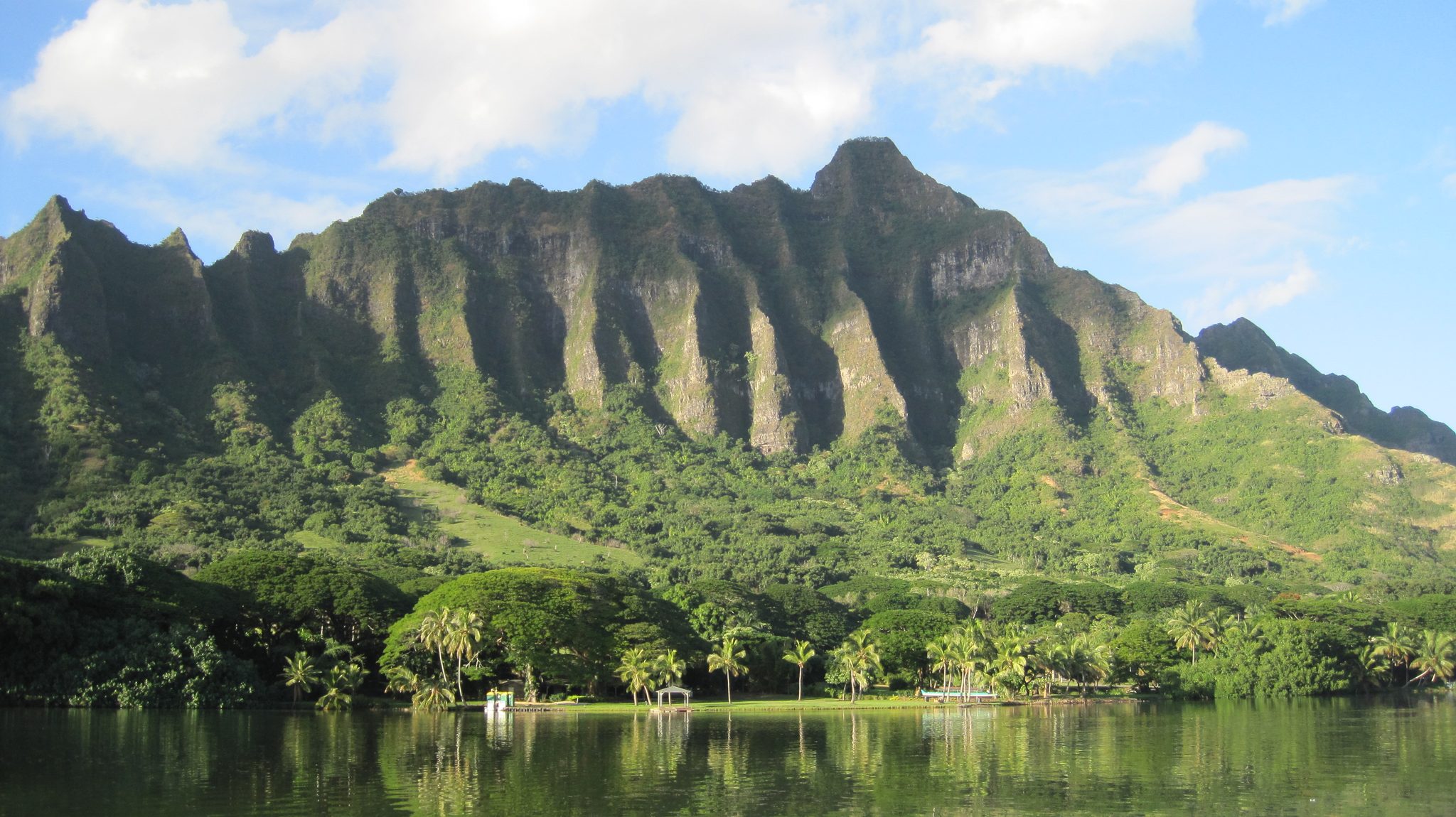 Moliʻi Fishpond at Kualoa Ranch on Oahu, with the green cliffs of Kualoa ridge behind it