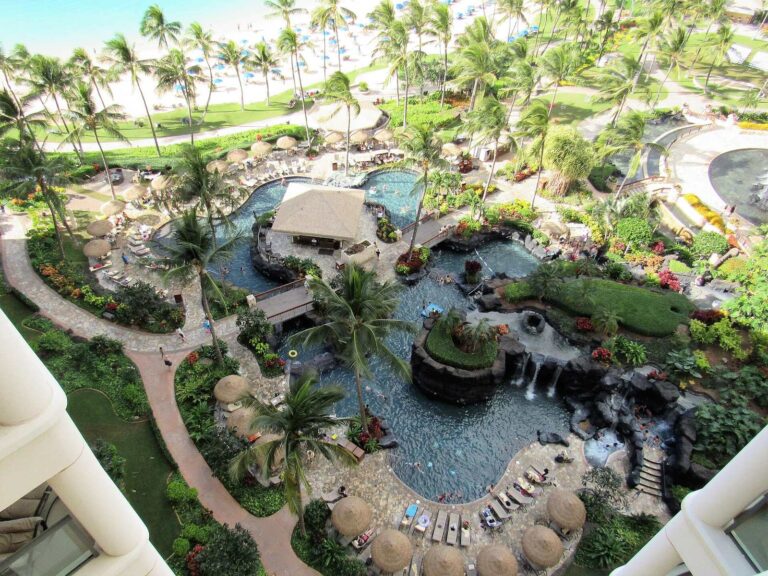 A rock-lined pool with waterfalls and palapas at Marriott's Ko Olina Beach Club
