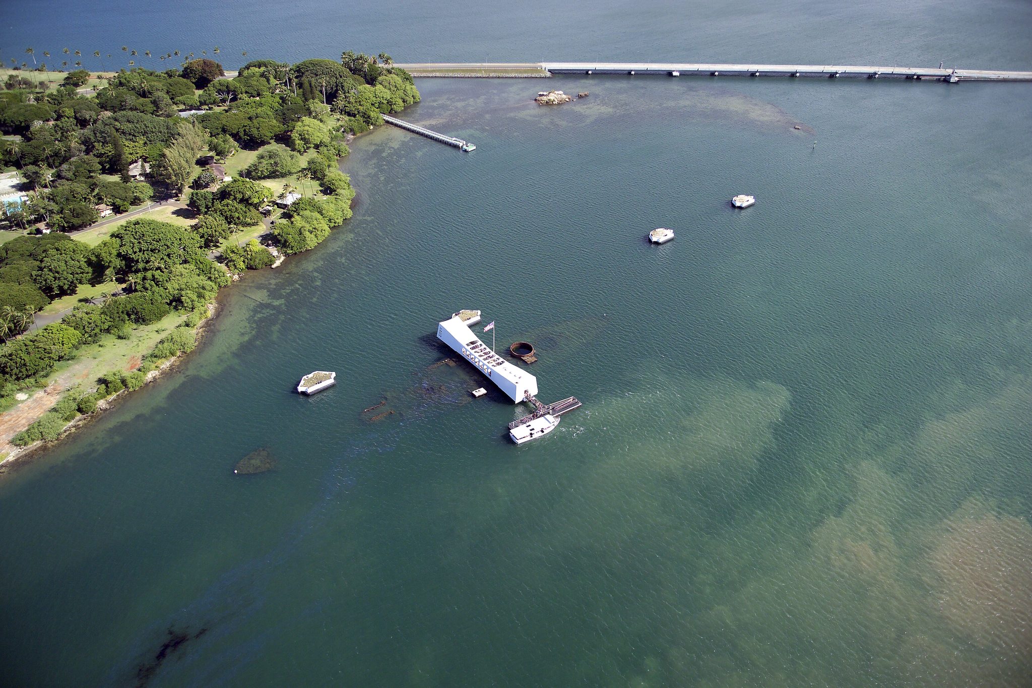 Aerial view of the USS Arizona Memorial at Pearl Harbor, the white memorial spanning the sunken battleship off Ford Island