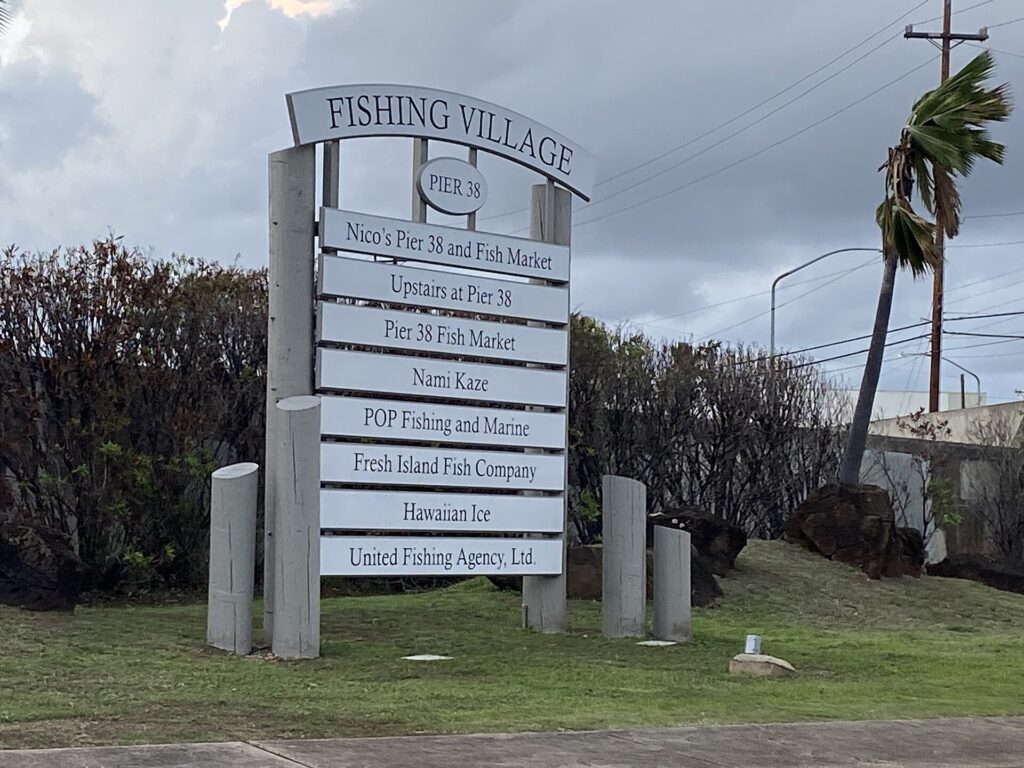 The Fishing Village sign at Pier 38 on Honolulu Harbor, listing Nico’s Pier 38