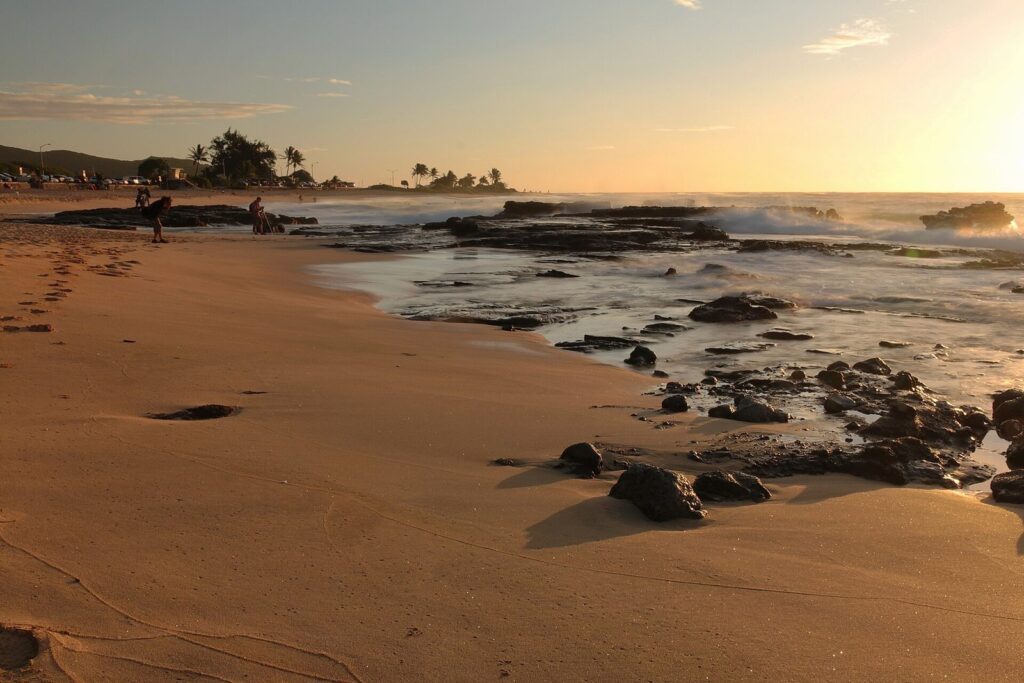 Sunrise over the sand and lava rock at Sandy Beach Park on Oahu's east side