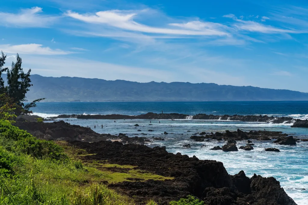 Shark's Cove on Oahu's North Shore: lava rock, tide pools and snorkelers in calm summer water
