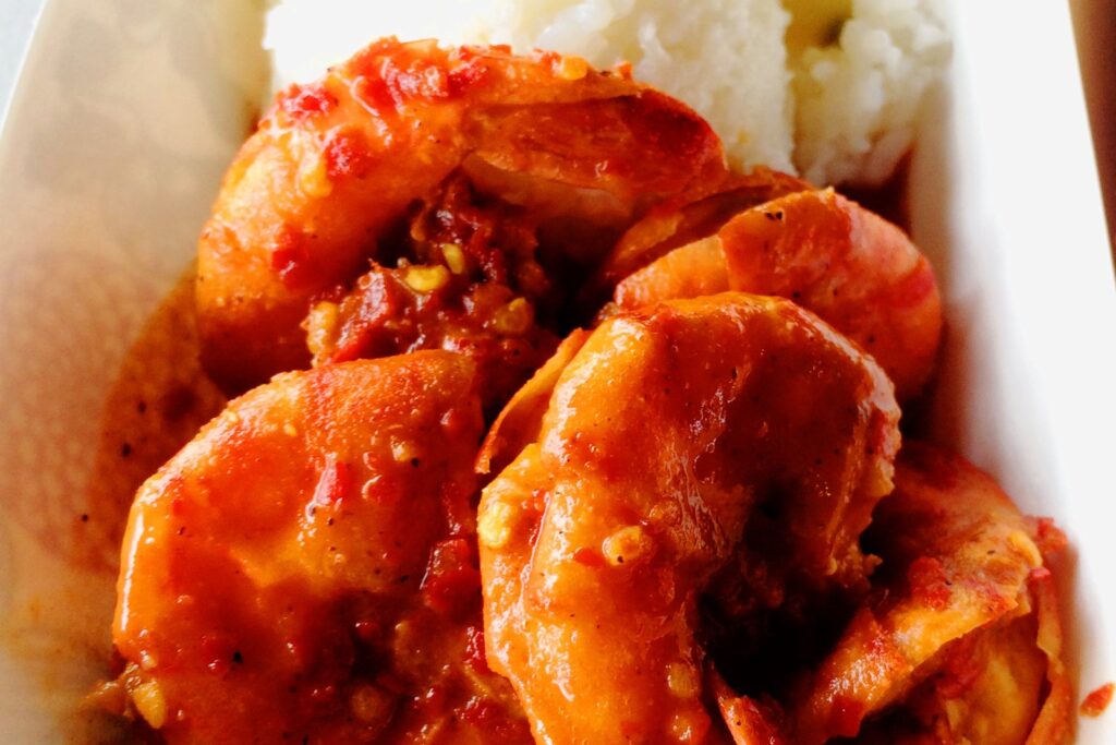 A plate of hot and spicy shrimp over rice from a North Shore shrimp truck