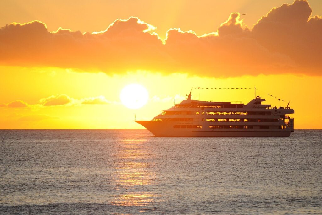 The Star of Honolulu dinner cruise ship on the water off Honolulu as the sun sets behind it