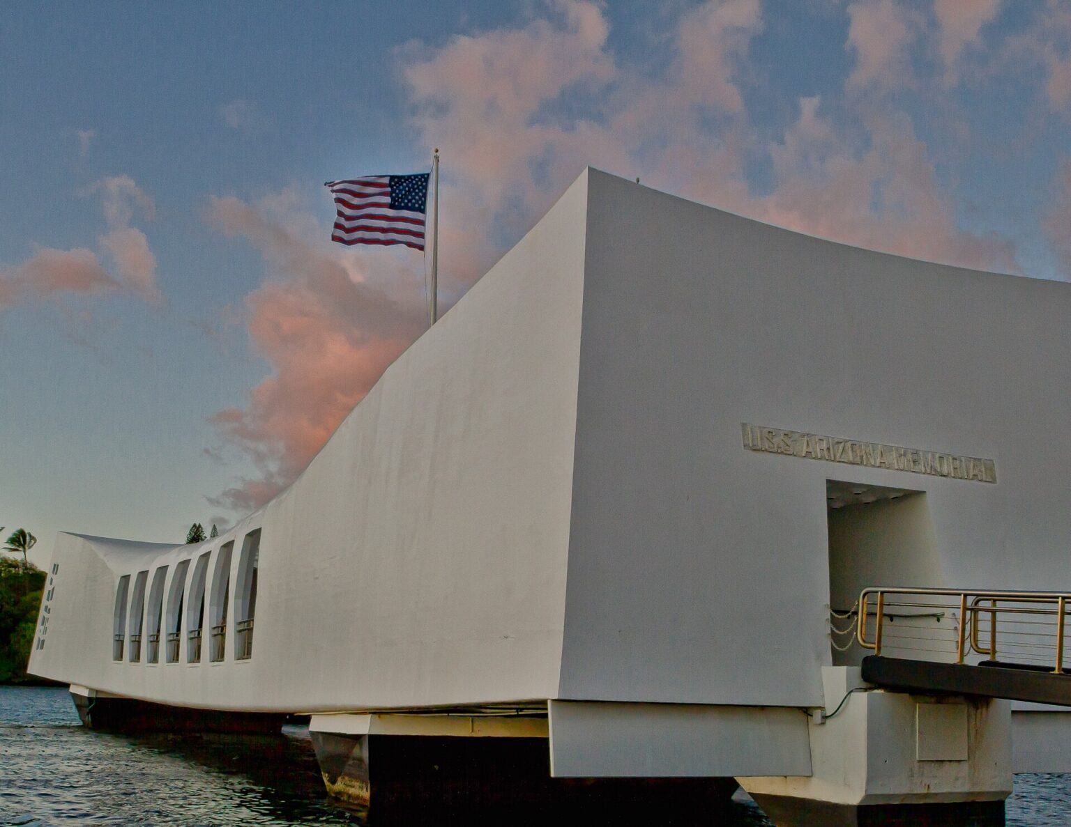 The white USS Arizona Memorial at Pearl Harbor, with the US flag flying above it