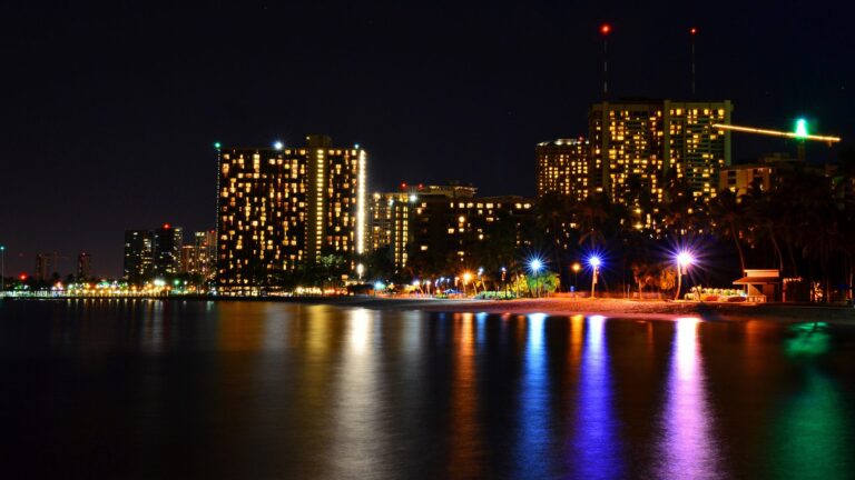 The Waikiki skyline lit up at night along the water