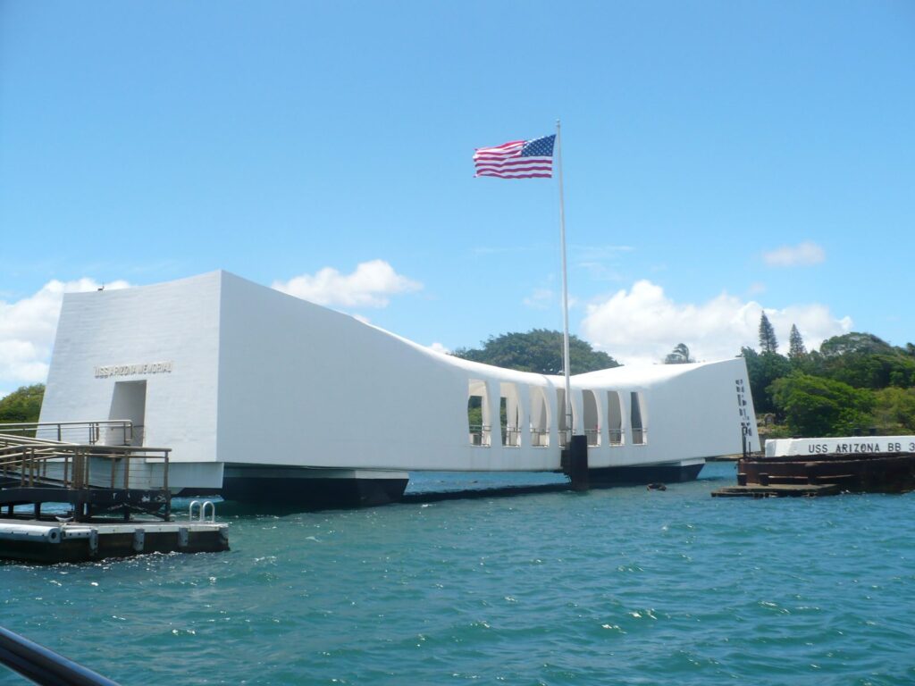The white USS Arizona Memorial and its flag seen from the Navy shuttle boat in Pearl Harbor