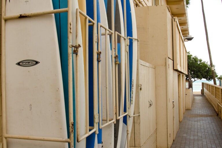 Surfboards racked along a walkway, seen from the Kaimana Beach Hotel