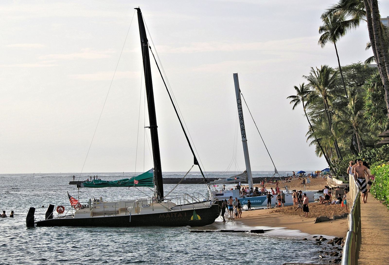 Catamarans pulled up on Waikiki Beach, ready for a sail
