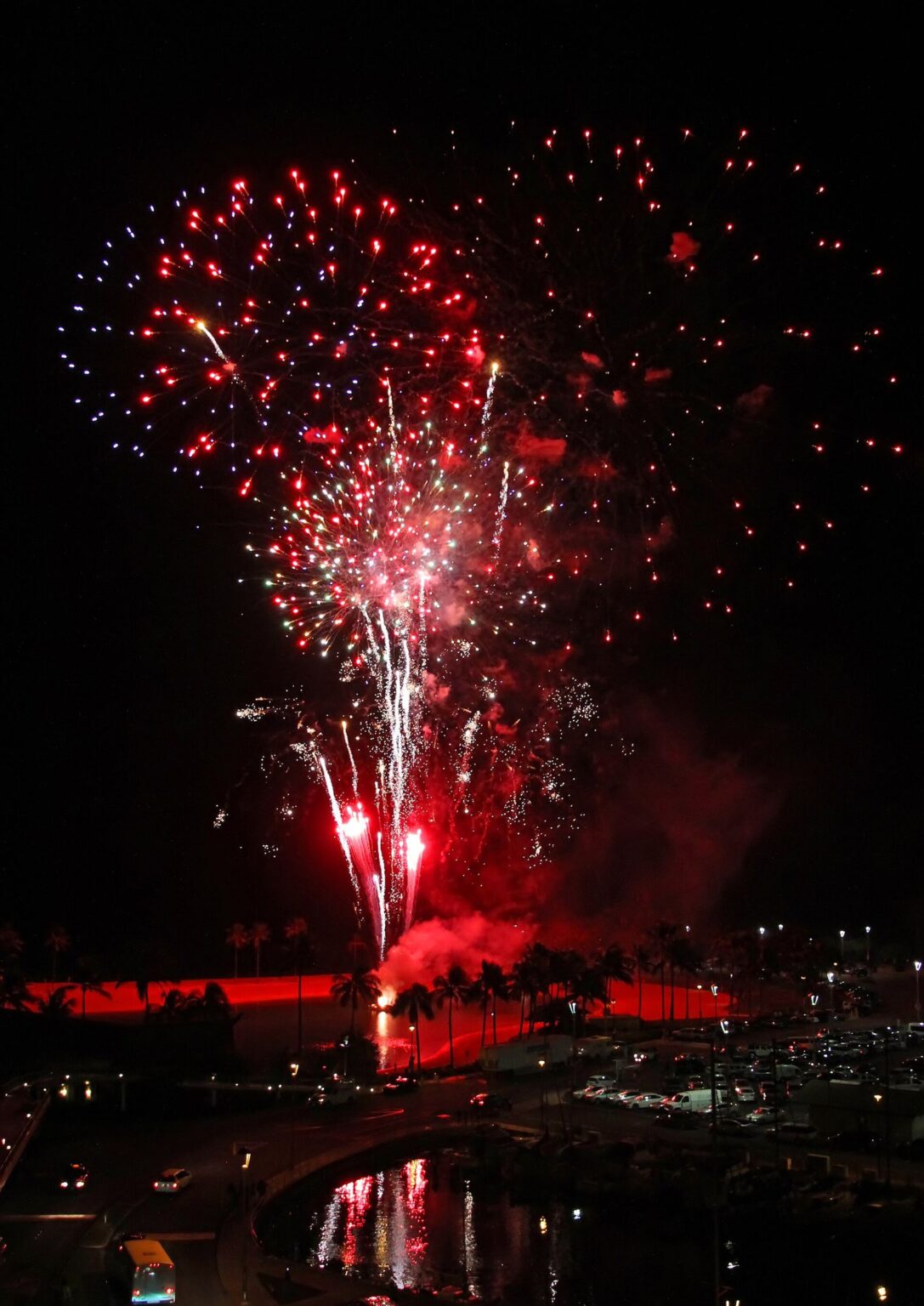 Red and white fireworks over the ocean in Waikiki at night