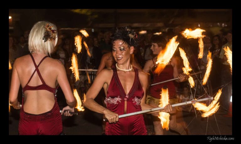 Fire performers spinning flaming umbrellas in front of a crowd at the Honolulu Night Market