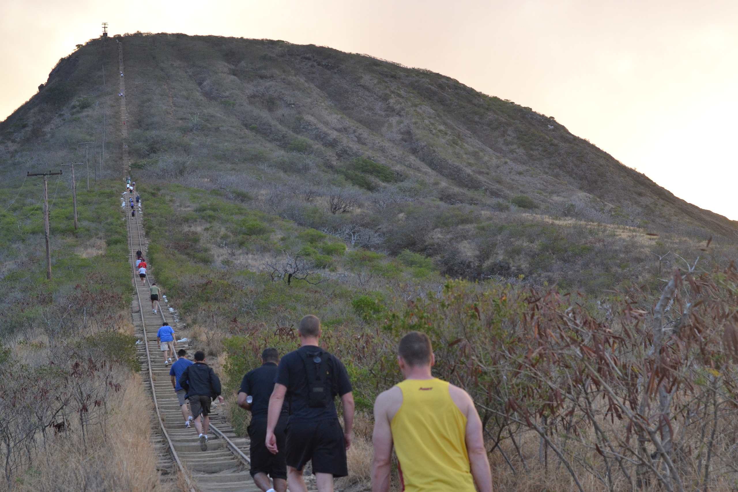 Hikers climbing the railway ties of the Koko Head stairs up the side of Koko Crater