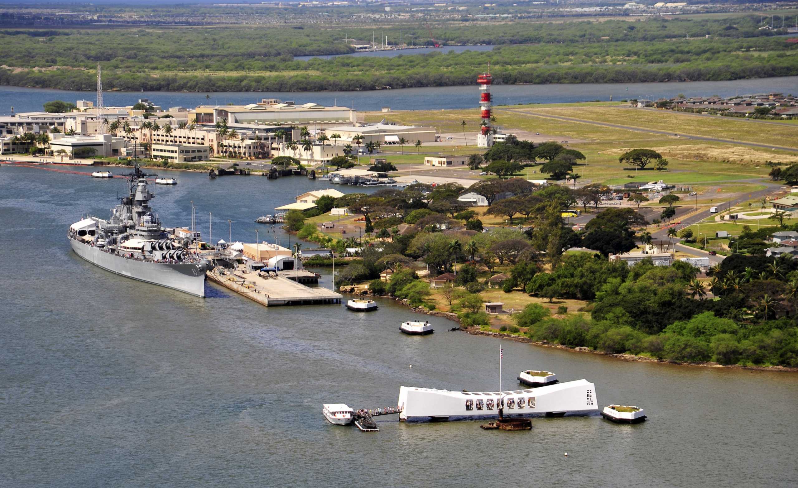 Aerial view of Pearl Harbor with the Battleship Missouri Memorial at Ford Island at left and the USS Arizona Memorial at right